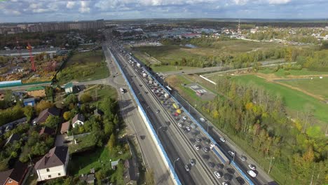 An-aerial-view-of-a-highway-with-a-busy-traffic-in-the-middle-of-the-country-scenery