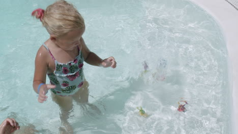 Niña-Juguetona-Con-Mamá-En-La-Piscina-Exterior