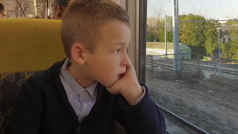 Junge-Schaut-Durch-Das-Zugfenster-Und-Versucht,-Von-Seinen-Gedanken-Abzulenken