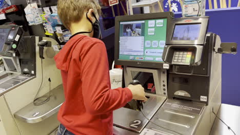 El-Niño-Ayuda-A-Su-Madre-A-Comprar-Comida-En-El-Supermercado-De-Autoservicio.