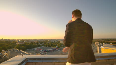 Un-Hombre-Y-Una-Mujer-Parados-En-El-Techo-Al-Atardecer-Se-Abrazan-Y-Miran-La-Hermosa-Vista.