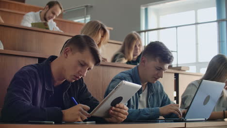 Large-Group-of-Multi-Ethnic-Students-Working-on-the-Laptops-while-Listening-to-a-Lecture-in-the-Modern-Classroom.-Bright-Young-People-Study-at-University.