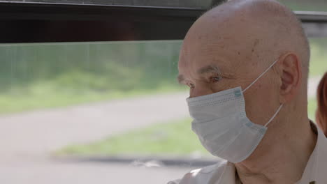 Älterer-Mann-Mit-Medizinischer-Maske-Sitzt-In-Einem-Bus