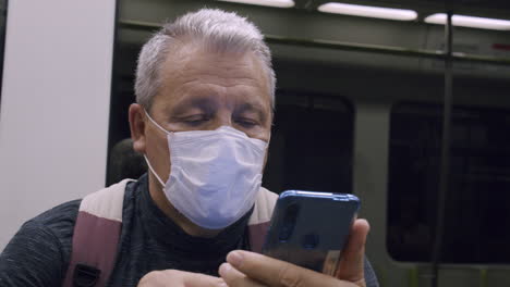 Senior-commuter-using-mobile-in-subway