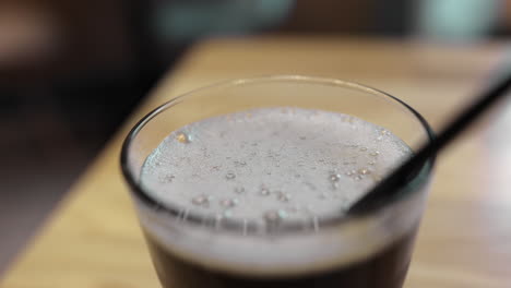 Pouring-refreshing-fizzy-drink-into-glass-with-straw