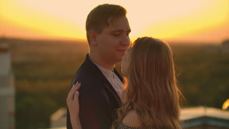 Two-lovers-embracing-dancing-on-top-of-a-skyscraper-overlooking-the-city-at-sunrise-sunset.-Romantic-setting