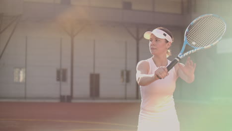 A-professional-woman-in-a-white-tight-suit-hits-the-ball-with-a-racket-and-dynamically-plays-on-the-tennis-court.