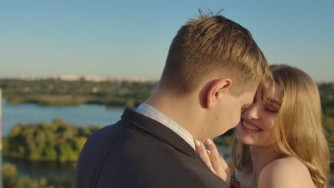 Young-couple-in-love-standing-on-the-roof-hug-and-closely-look-at-each-other.-Romantic-evening-on-the-roof-of-the-building.-A-date-on-the-roof-of-a-building-love.-Slow-motion