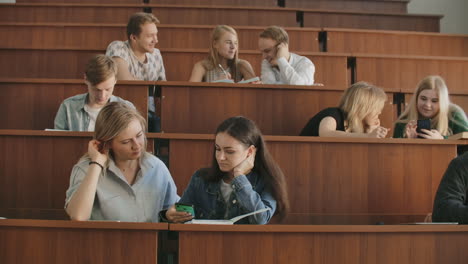 Fröhliche-Studenten-Benutzen-Smartphones-Und-Chatten-Während-Der-Pause-Zwischen-Den-Vorlesungen-An-Der-Universität.-Moderne-Technologie.-Fröhliche-Studenten-Einer-Multiethnischen-Gruppe-Sind