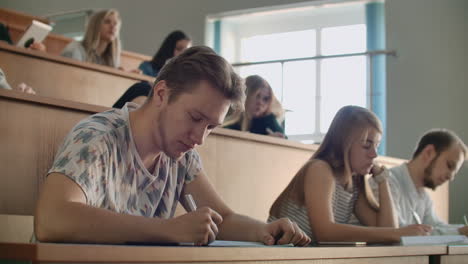 Students-at-a-university-or-college-write-a-lecture-on-a-laptop.-Graduate-at-the-Institute.