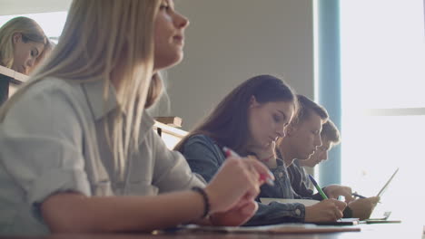 Eine-Gruppe-Männlicher-Und-Weiblicher-Studenten-Lauscht-In-Einem-Großen-Hörsaal-Der-Universität-Der-Vorlesung-Eines-Professors.