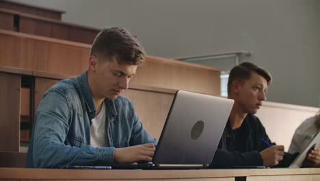 Students-at-a-university-or-college-write-a-lecture-on-a-laptop.-Graduate-at-the-Institute.