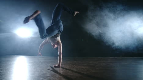 Ballet-Moderno-Un-Hombre-Sentado-En-El-Escenario-Salta-Hacia-Atrás-Con-Rotación-En-Un-Escenario-Oscuro-En-El-Humo-En-El-Centro-De-Atención.