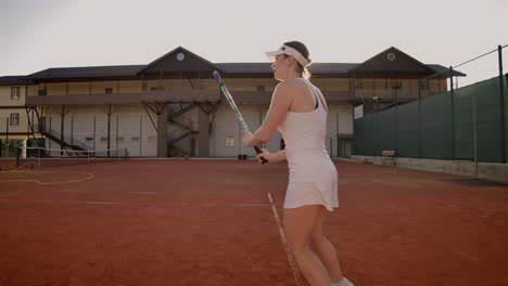 Tennis-game-on-sunny-day-at-tennis-court-young-sportive-woman-playing-professional-tennis.