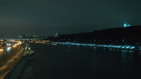 Train-moving-through-night-Moscow-and-crossing-the-bridge-window-view