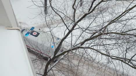 Ambulance-vehicle-with-flashing-lights-on-winter-road