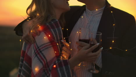 Two-lovers-standing-on-the-roof-with-wine-look-at-each-other-and-enjoy-a-romantic-evening-on-the-roof