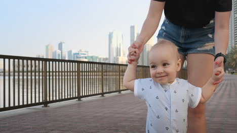 In-the-summer-a-young-mother-walking-with-a-child-along-the-promenade.