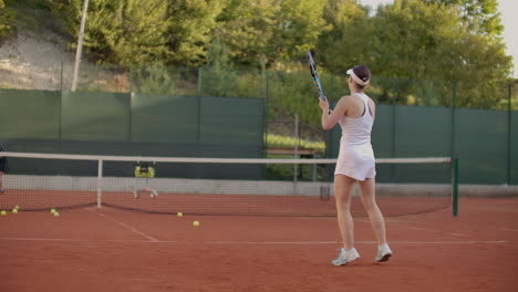 Eine-Tennisspielerin-übt-Das-Schlagen-Des-Balls,-Während-Der-Trainer-In-Zeitlupe-Mit-Einem-Schläger-Auf-Den-Ball-Schlägt.-Training-Einer-Professionellen-Tennisspielerin.