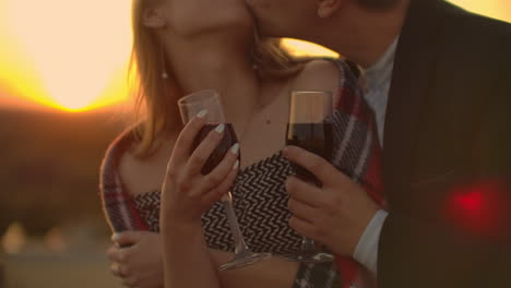 Cerrar-Las-Manos-De-Mujeres-Sosteniendo-Copas-De-Vino-Tinto-En-El-Balcón-Durante-El-Concepto-De-Celebración-Al-Atardecer