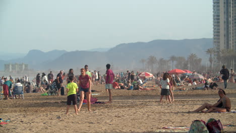 Pintoresca-Playa-Llena-De-Gente-Relajándose-Y-Jugando-Tenis