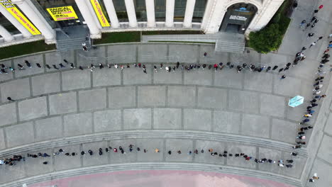 People-waiting-turn-in-long-queue-to-Radical-Market-aerial-view