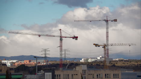 Paisaje-Urbano-Con-Grúas-De-Construcción-Y-Montañas