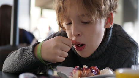 Niño-Comiendo-Pastel-De-Bayas-De-Postre-En-La-Cafetería