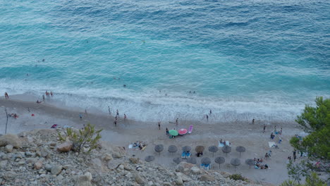 Vista-Superior---Gente-Descansando-En-La-Costa-Del-Mar