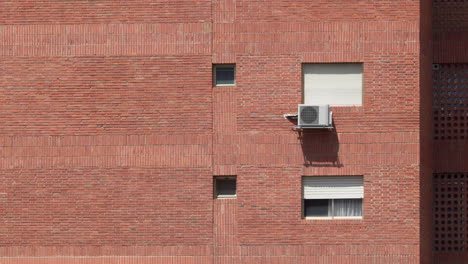 Pared-De-Ladrillo-Con-Ventanas-Y-Aire-Acondicionado.