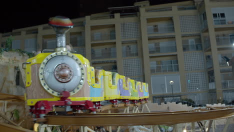 Children-riding-on-train-roller-coaster-in-outdoor-funfair