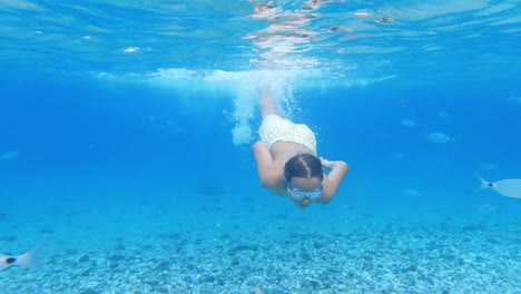 Teenager-Schwimmt-Unter-Wasser,-Umgeben-Von-Fischen