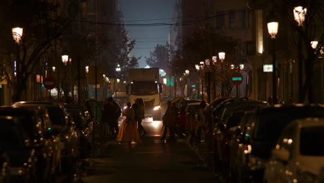 Calle-Nocturna-Con-Gente-Caminando-Y-Camiones-En-La-Carretera-España