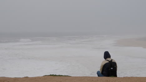 Man-sitting-on-the-seashore
