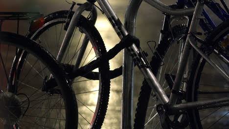 Parked-bicycles-city-at-night-during-rain