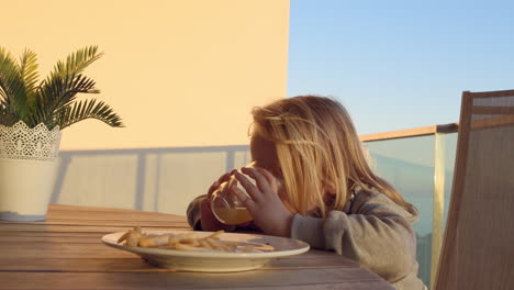 Child-finishing-her-meal-on-the-balcony