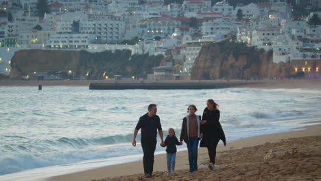 Family-evening-walk-along-ocean-coastline