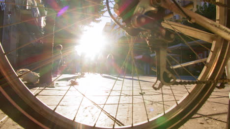 People-walking-behind-bicycle-wheel