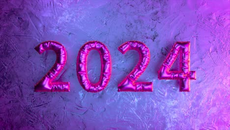Leuchtend-Rosa-Metallische-Luftballons-In-Form-Des-Jahres-2024-Vor-Einem-Gefrorenen,-Strukturierten-Hintergrund
