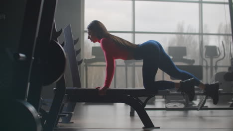 Una-Joven-Con-Un-Cuerpo-Musculoso-Y-Delgado-Realiza-Un-Entrenamiento-Circular-En-El-Gimnasio.-Su-Pierna-Izquierda-Está-Doblada-Y-Su-Pierna-Derecha-Sube-Y-Baja-Para-Bombear-Las-Nalgas.