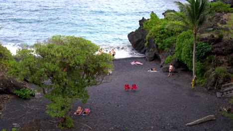 Overlooking-view-of-the-Black-Sand-Beach-in-Waianapanapa-State-Park-along-the-Road-to-Hana-in-East-Maui,-Hawaii,-a-popular-tourist-destination-along-the-Road-to-Hana