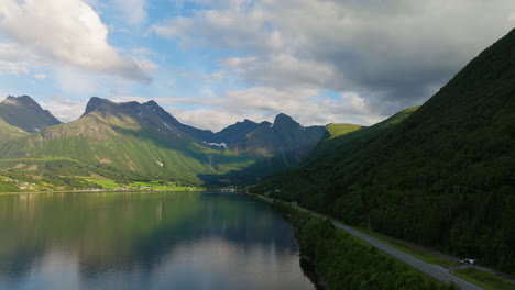 Fjord-water,-hills,-forests-and-magnificent-mountain-range-background