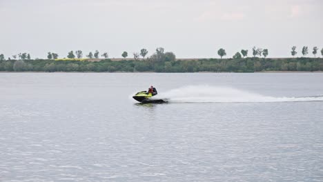 A-water-scooter-sailing-Through-the-Lake,-Creating-a-Splash-of-White-Water-in-its-Wake---Wide-slow-motion-Shot