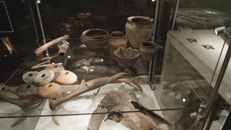 Huesos-Antiguos,-Vasijas-Y-Cráneos-En-Vitrina-En-La-Exposición-En-El-Museo-De-Biskupin,-Polonia