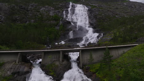 Aerial-panning-view,-waterfall-flowing-down-mountain-side