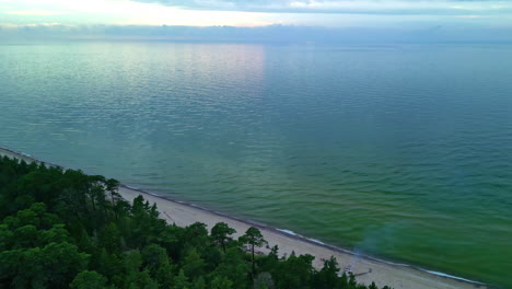 Aerial-drone-reveal-shot-of-a-remote-empty-beach-on-a-cloudy-day