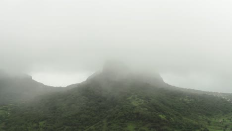 The-drone-is-moving-to-the-camera-side,-where-the-mountains-are-no-longer-visible-due-to-Fogg