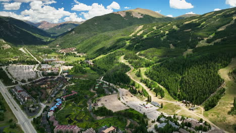 Summer-Keystone-Breckenridge-Colorado-Vail-resort-Epic-Pass-entrance-ski-snowboard-bike-biking-biker-gondola-runs-aerial-cinematic-drone-high-altitude-blue-sky-afternoon-clouds-slowly-pan-up-motion