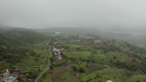 The-drone-is-moving-towards-the-camera-side,-where-there-are-many-houses-on-the-hills