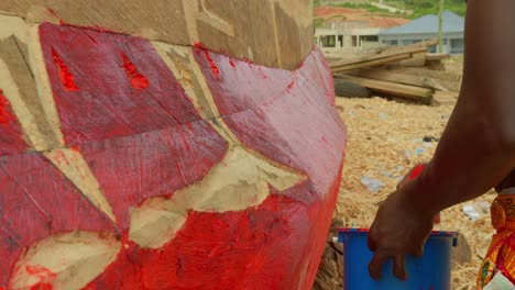 Schwarzer-Männlicher-Fischer-Bemalt-Sein-Holzboot-In-Rot-Am-Tropischen-Sandstrand-Der-Westküste